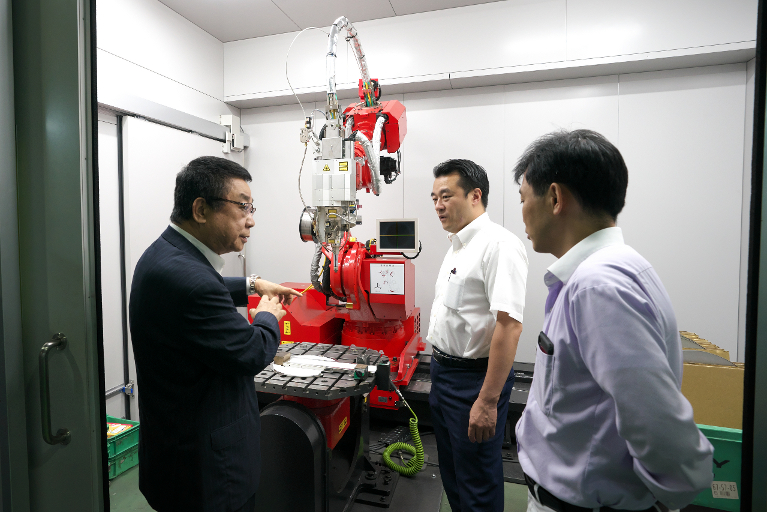 最新の溶接ロボットを見学中の大岡議員と弊社代表坪田